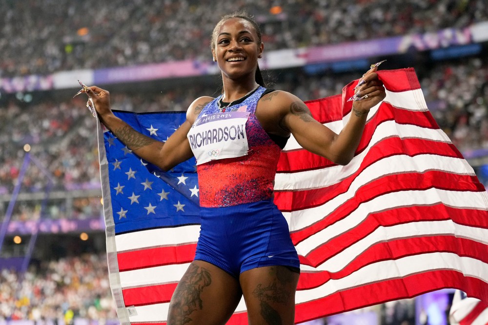 Sha'carri Richardson holds the U.S. flag.