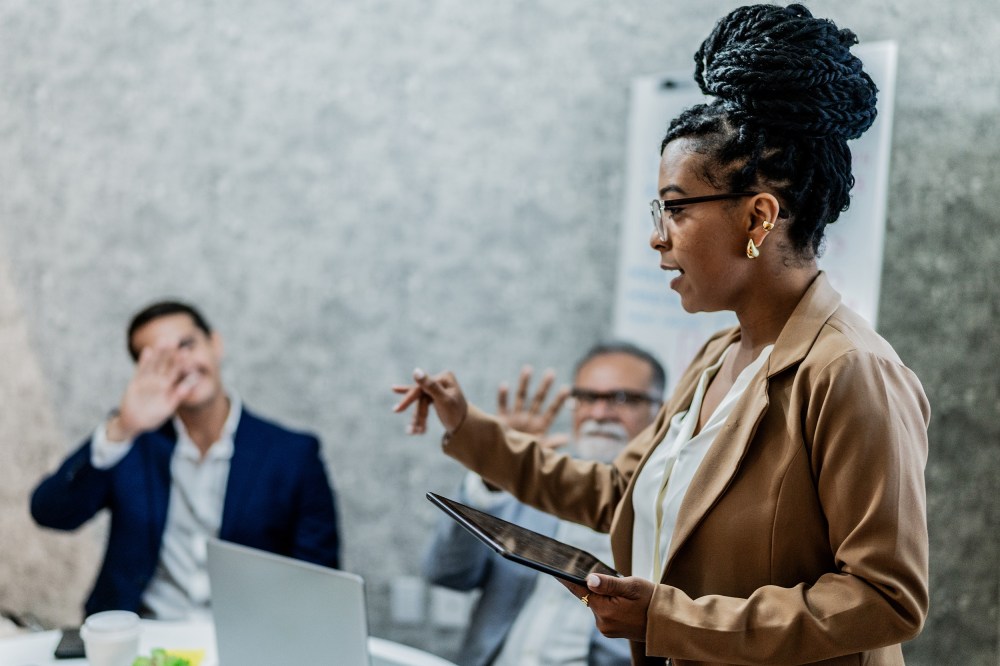Businesswoman talking with coworkers in business meeting at office