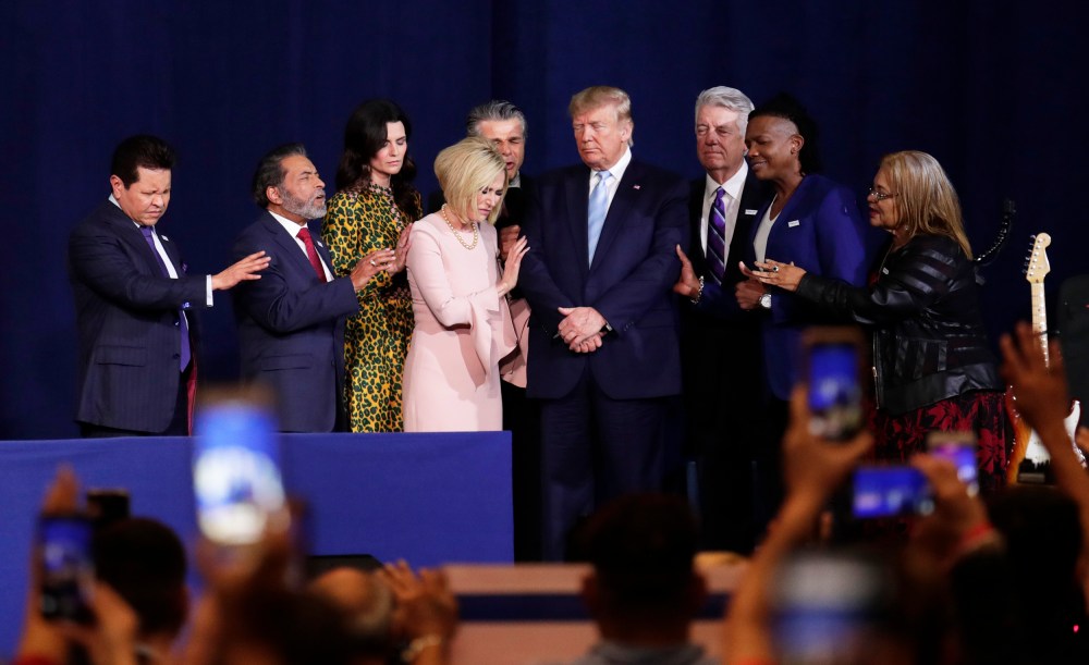 Pastor Paula White, third from left, and other faith leaders pray with President Donald Trump.