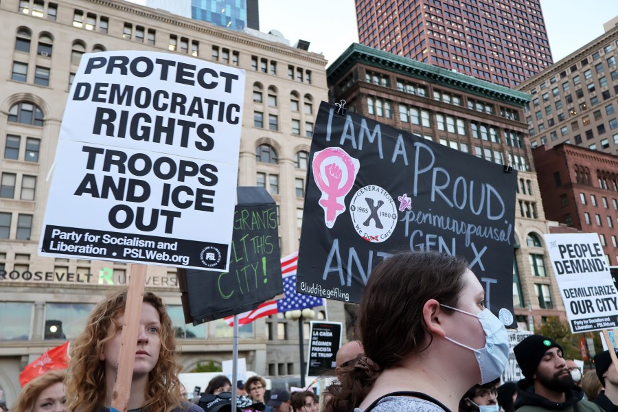 Anti-ICE protesters holding up signs in Chicago.