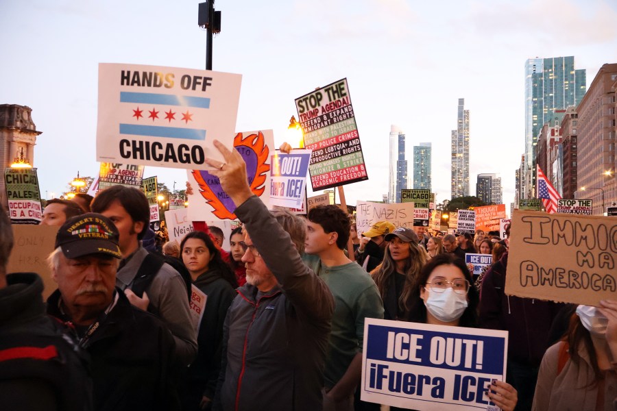 Anti-ICE protesters holding up signs in Chicago.