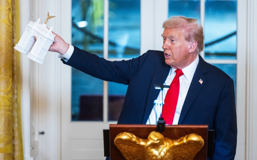 US President Donald Trump holds a model of the planned Triumph Arch.