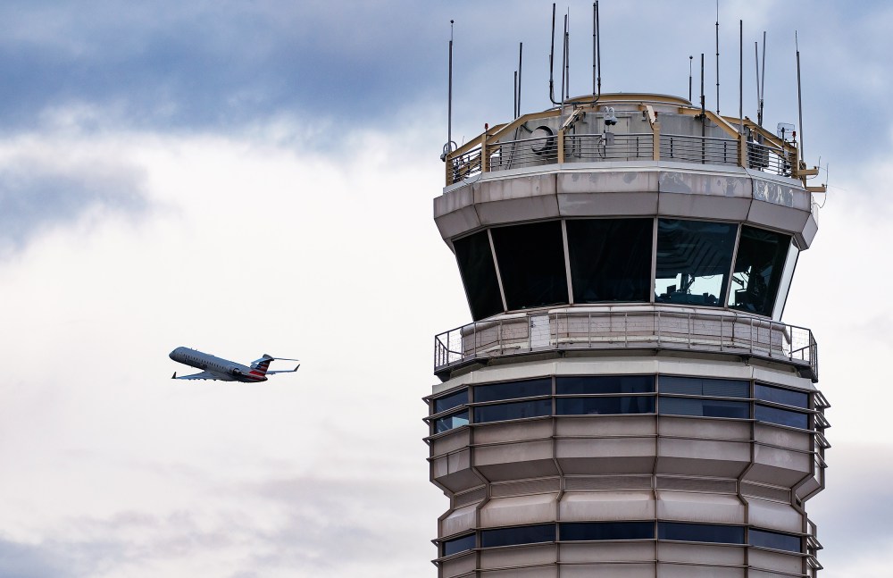 An American Eagle plane takes off near the air traffic control tower.