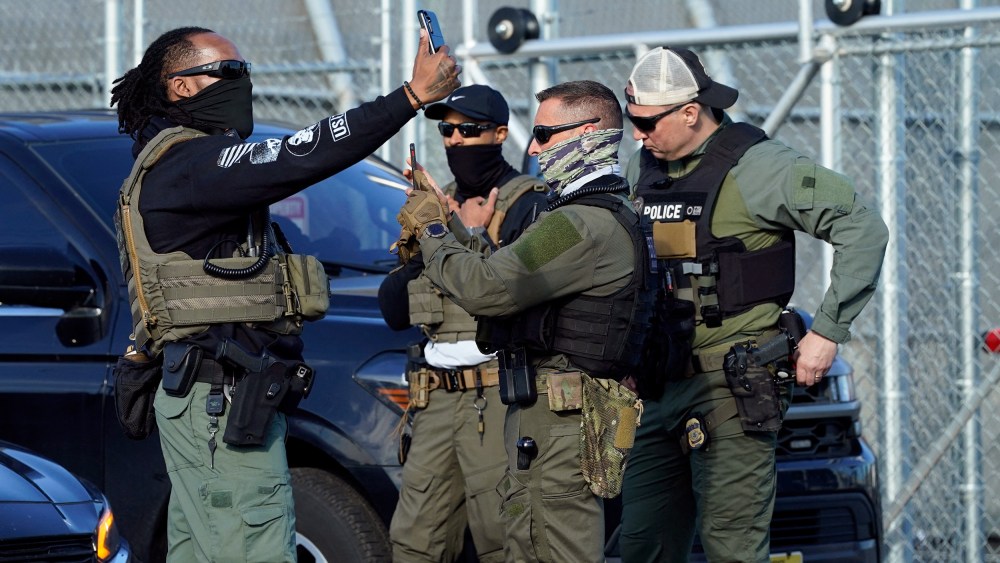 ICE agents use their phones near protestors at a demonstration in Newark, N.J. on May 7, 2025.