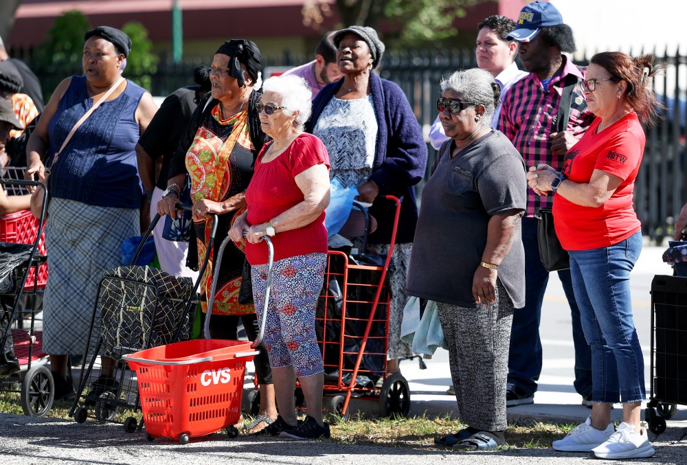 People wait in line to receive groceries from a food bank in Miami, F.L.