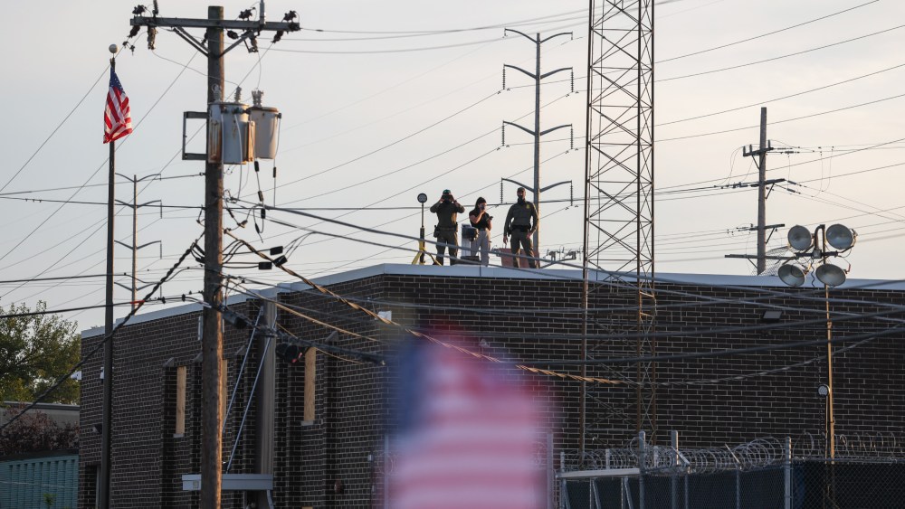 People on the roof of the immigration processing and detention center watch demonstrators in Broadview, I.L.