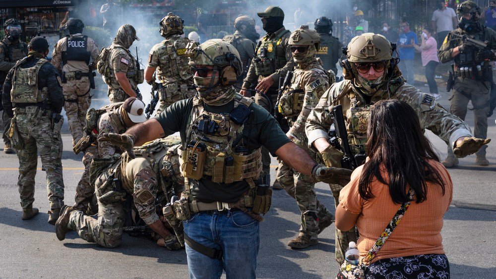 Police take two people into custody, as tear gas fills the air after it was used by federal law enforcement agents in Broadview, IL.