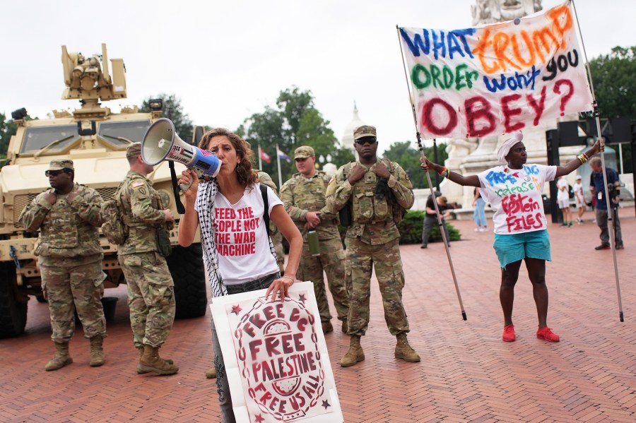 Protesters demonstrate near members of the National Guard  in Washington, D.C.