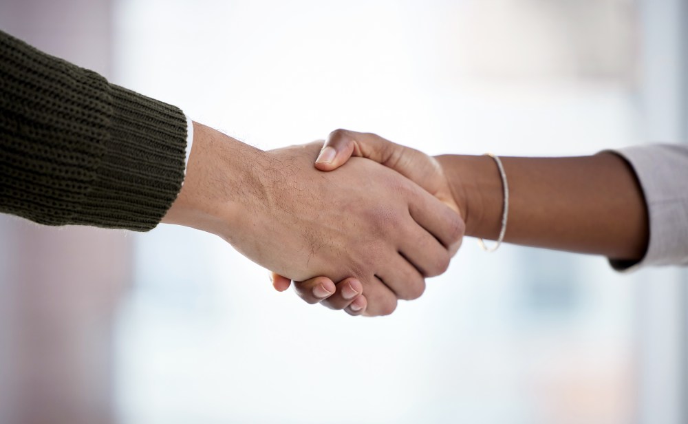 Closeup shot of two businesspeople shaking hands in an office.