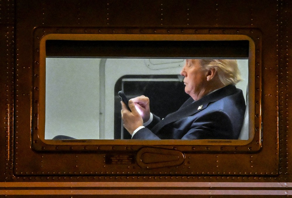 US President Donald Trump uses a cellphone aboard Marine One.