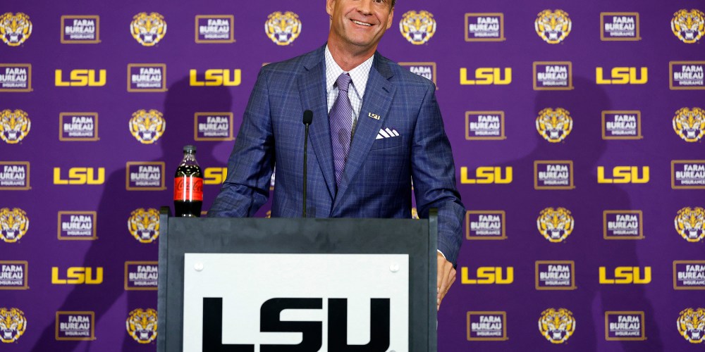 Lane Kiffin stands behind a podium at a press conference at Tiger Stadium in Baton Rouge, L.A.