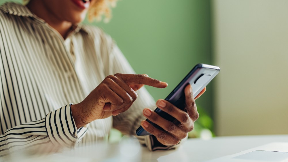 African American woman using social media on her phone.