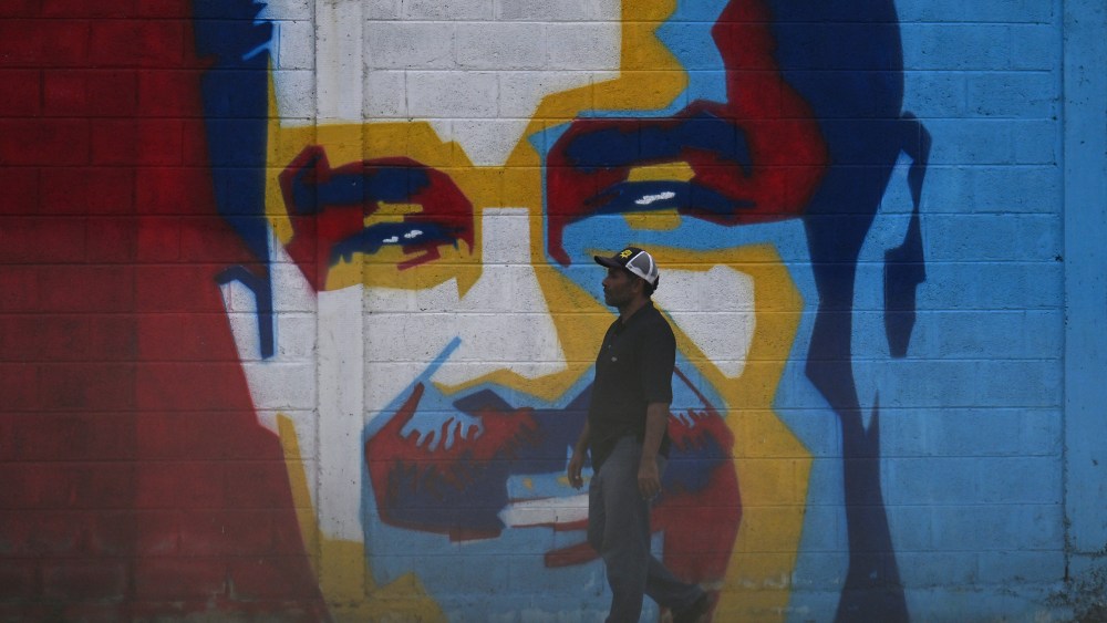 A man walks past a graffiti depicting Venezuelan President Nicolas Maduro in Caracas on January 3, 2026.