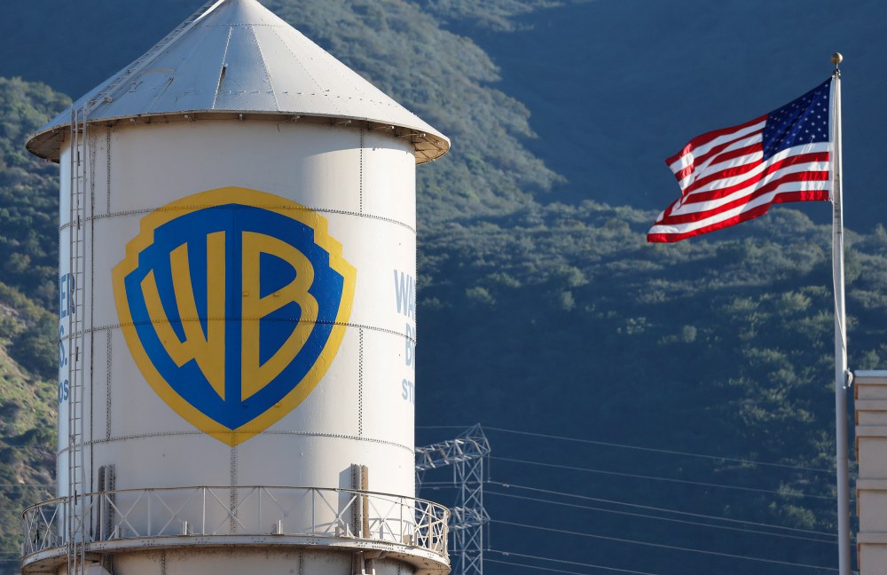 Warner Bros. logo is seen on the left, and the American flag is on the right.