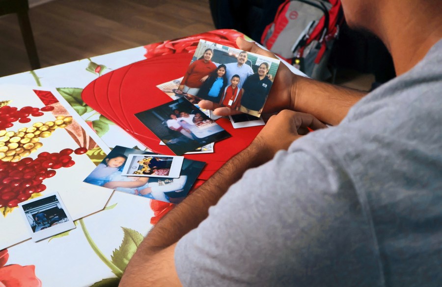 Arnoldo Bazán holds a family photo of himself, his father Arnulfo, and his three older sisters, Maria, Selena and Samantha.
