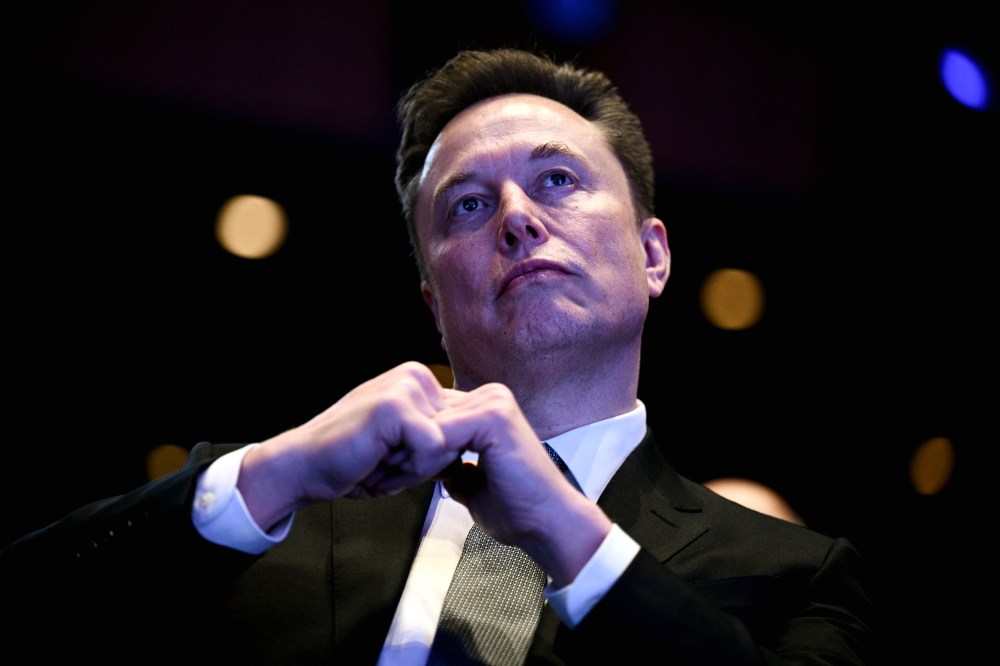 Elon Musk looking up at the stage while President Trump speaks.