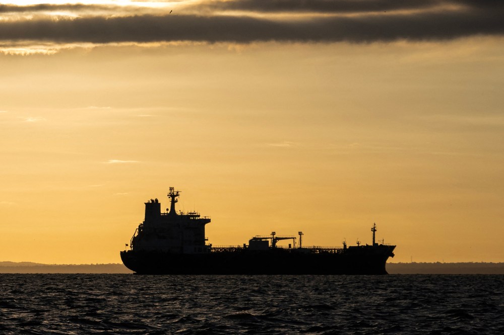 The silhouette of an oil tanker at sunrise.
