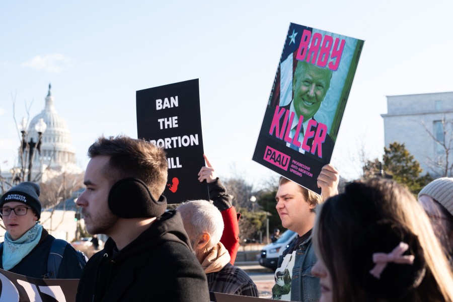 Activists holding signs seen in a tight frame. 