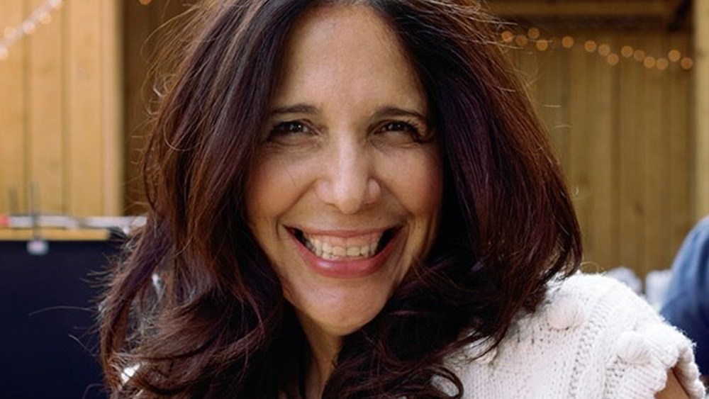 Sue Zarco Kramer smiles at an outside venue.