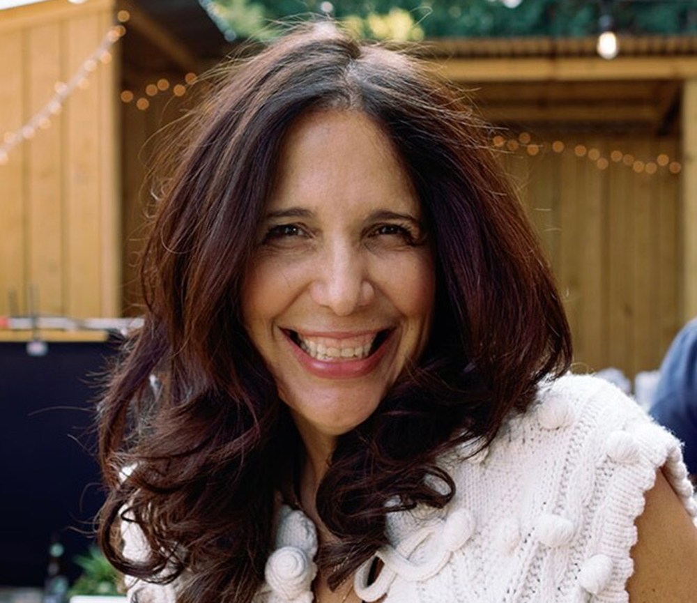 Sue Zarco Kramer smiles at an outside venue.