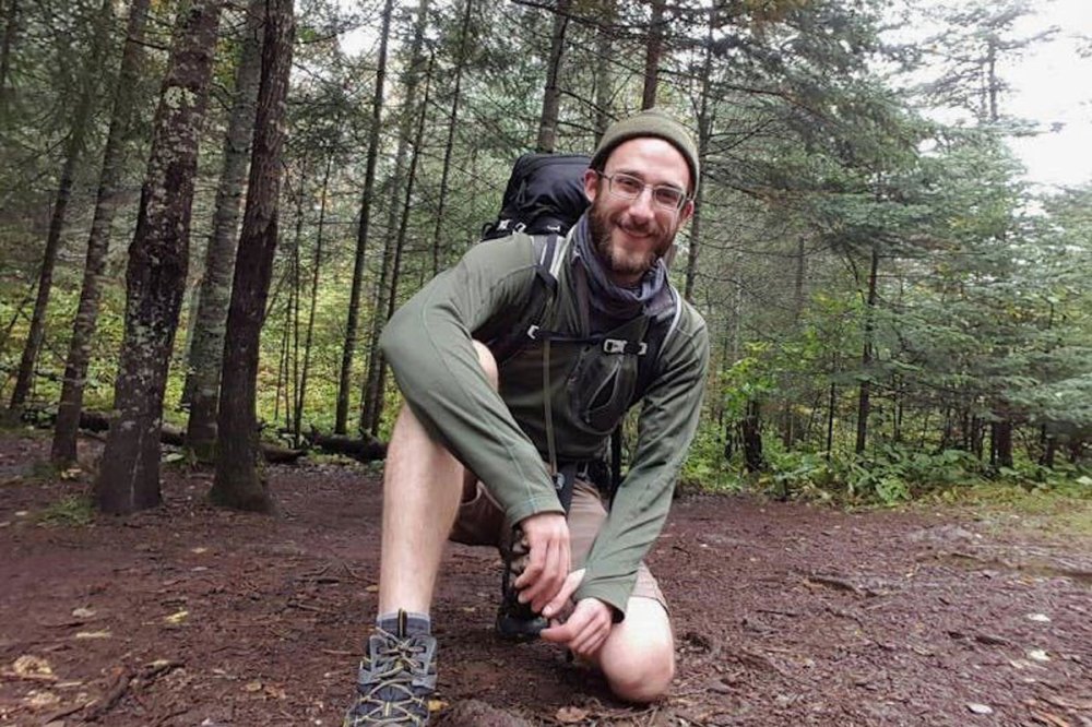 A selfie of a man backpacking in the woods