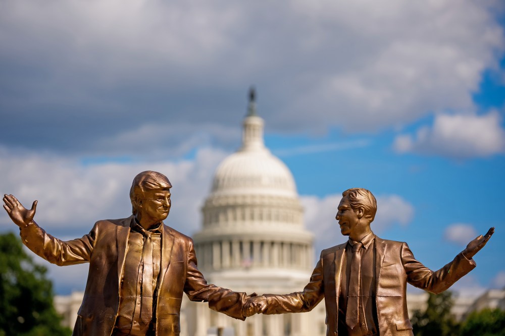 A golden statue depicts Donald Trump, left, and Jeffrey Epstein holding hands. In the background, the Capitol is out of focus.