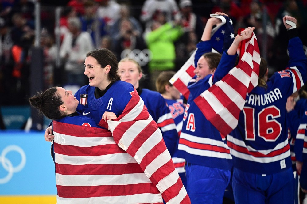 Hockey players in jerseys that read "USA" celebrate with American flags.