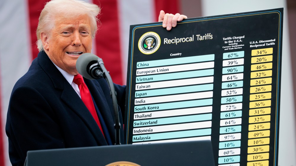 President Donald Trump holds up a chart of "reciprocal tariffs" while speaking during a “Make America Wealthy Again” trade announcement event.