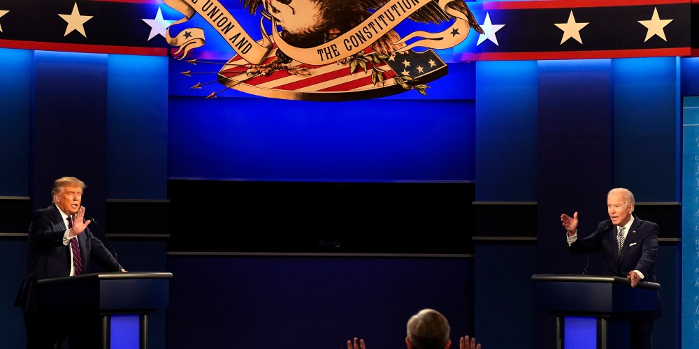Donald Trump, left, and Joe Biden, right, raise their hands as they speak.