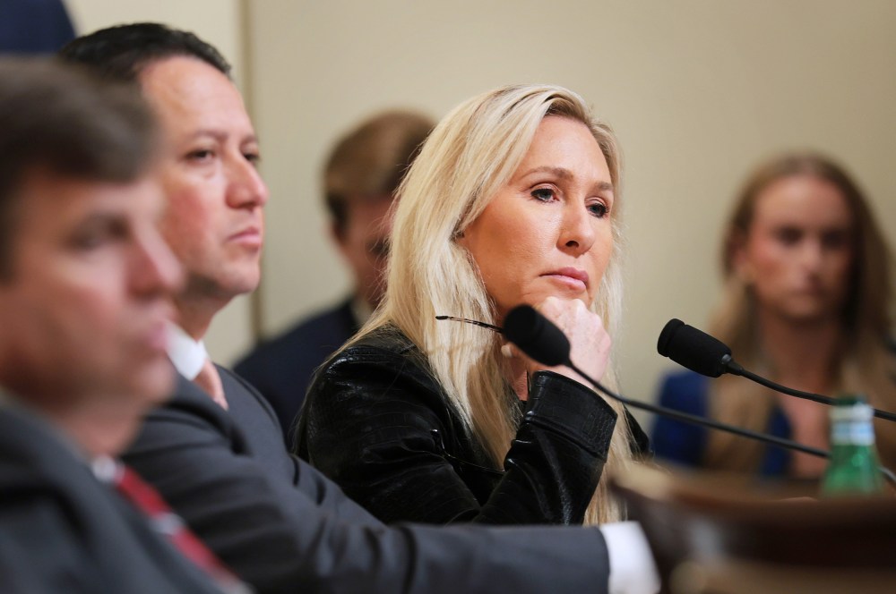 Marjorie Taylor Greene looks on as she sits along with other representatives.