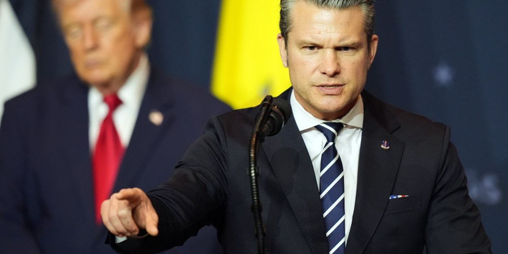 Defense Secretary Pete Hegseth speaks while President Donald Trump, left, listens.