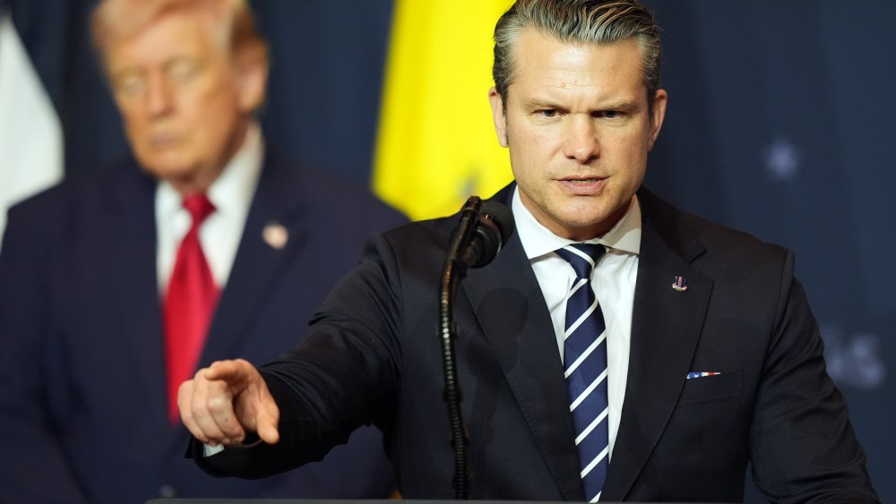 Defense Secretary Pete Hegseth speaks while President Donald Trump, left, listens.