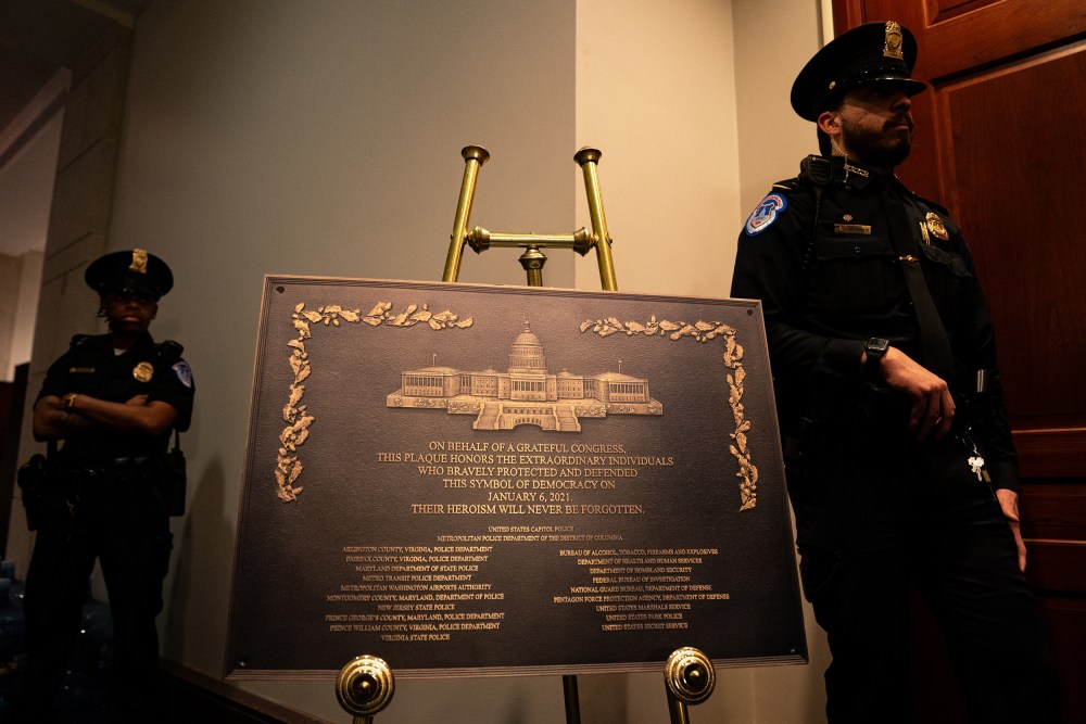 A plaque stands between two officers.