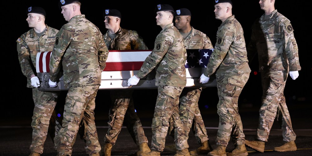 A U.S. Army carry team moves a flag-draped transfer case containing the remains of Maj. Sorffly Davius, 46, at Dover Air Force Base.