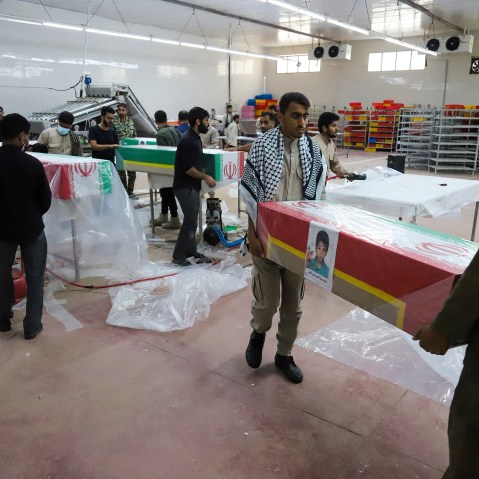 Men carry a casket with a little girl's photo on it.