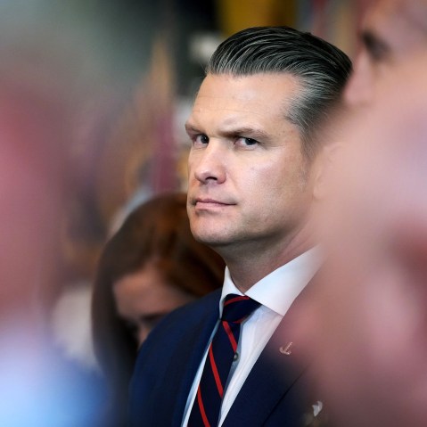 Pege Hegseth’s profile can be seen among other people who are out of focus.
