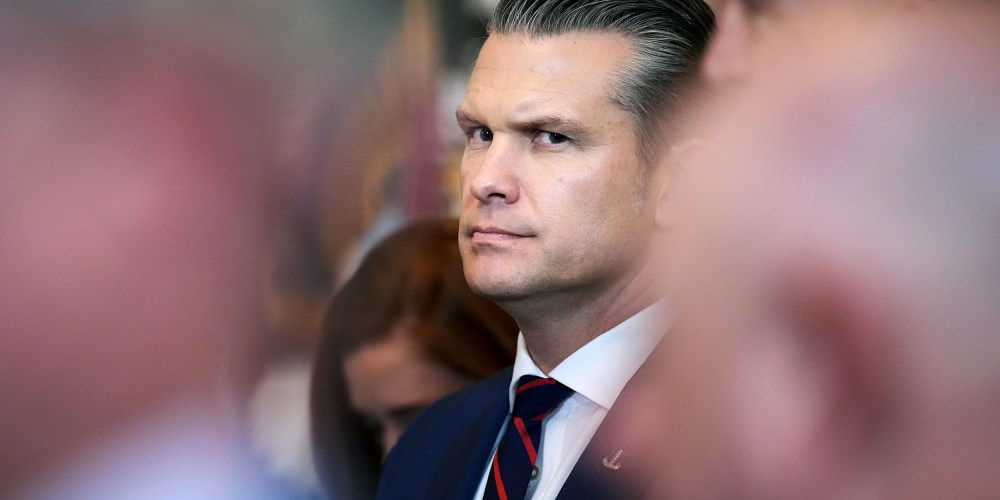 Pege Hegseth’s profile can be seen among other people who are out of focus.