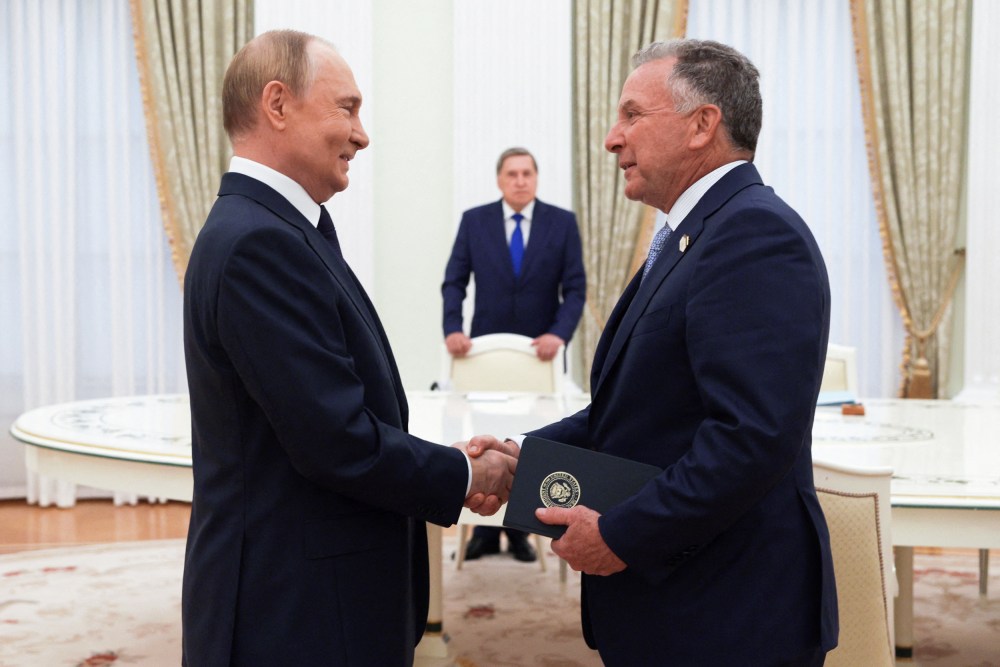 Vladimir Putin, left, shakes hands with Steve Witkoff.